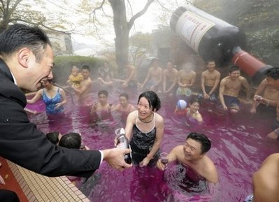 A waiter serves you red wine, while you are already bathing in it.