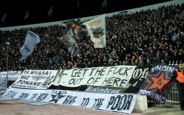 And we stay in Greece. This is PAOK Salonica. Their banner says singing and drinking. PAOK-fans are known to mix cola with a cheap Greek retsina called Malamatina. This cocktail is called Touba Libre, after their stadium Touba.