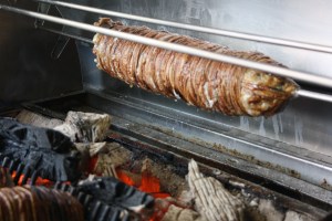 Kokoreç on a spit over a wood fire.