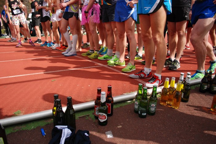 Contestants and beers are lined up before the start of a Beer Mile.