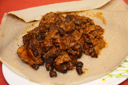 Quanta firfir served on a fresh injera. This is a typical breakfast meal in Ethiopia that cures hangovers.